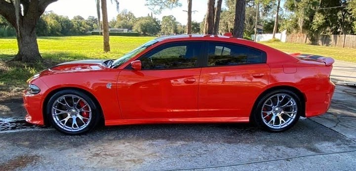 Orange Dodge Charger Hellcat with chrome wheels after detailing