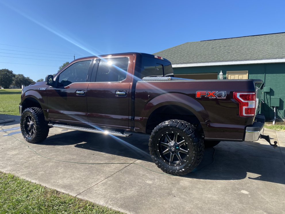Lifted maroon Ford F-150 gleaming after wash and wax in Leesburg, FL
