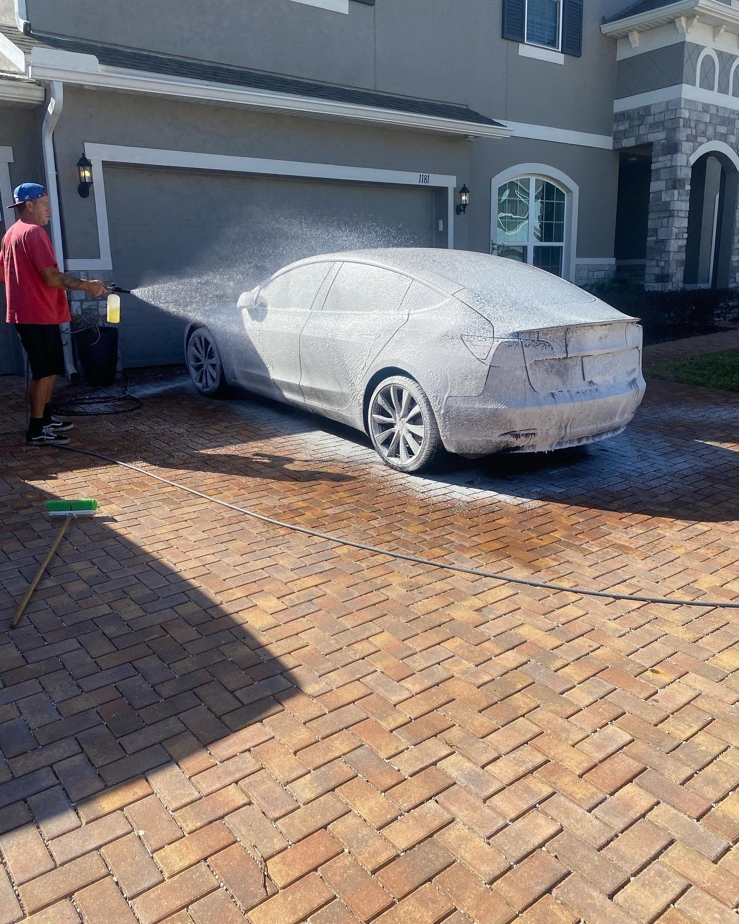 Tesla Model 3 covered in foam during a mobile detail in Clermont, FL